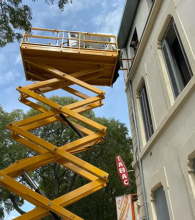 Nacelle élévatrice en action pour installer un spa haut de gamme par les airs sur une façade d'immeuble, illustrant le service de livraison technique d'Azur Spa Design.