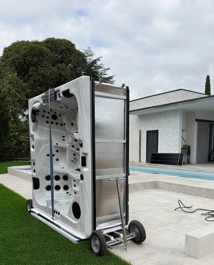 Un spa est acheminé facilement sur son lieu de pose définitif dans le jardin d'un client. Le cheminement et l'installation du spa est facilitée par l'utilisation d'une remrque qui permet de transporter le spa à la verticale