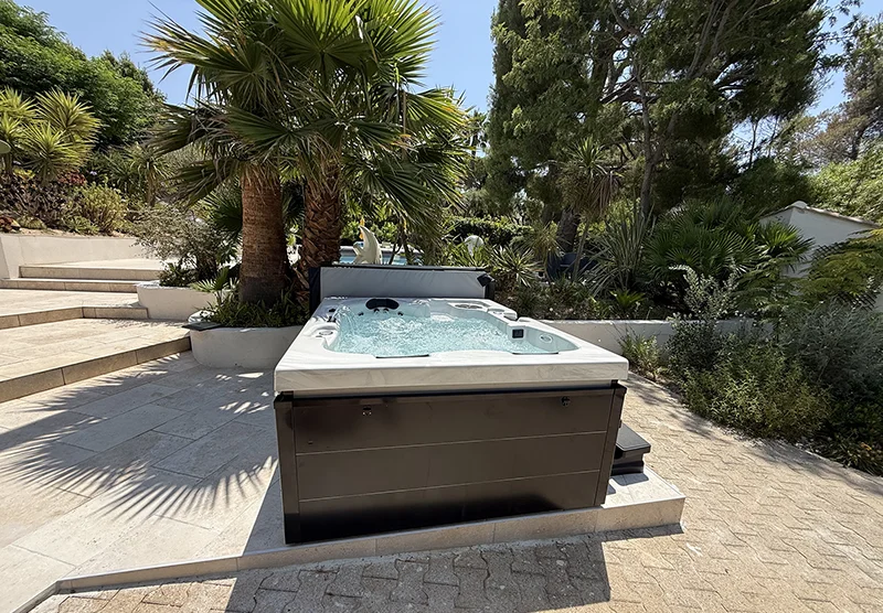 Installation d’un spa Torino Luxe New Giovanni Riboli sur une terrasse carrelée à niveaux dans une maison contemporaine à Sanary-sur-Mer