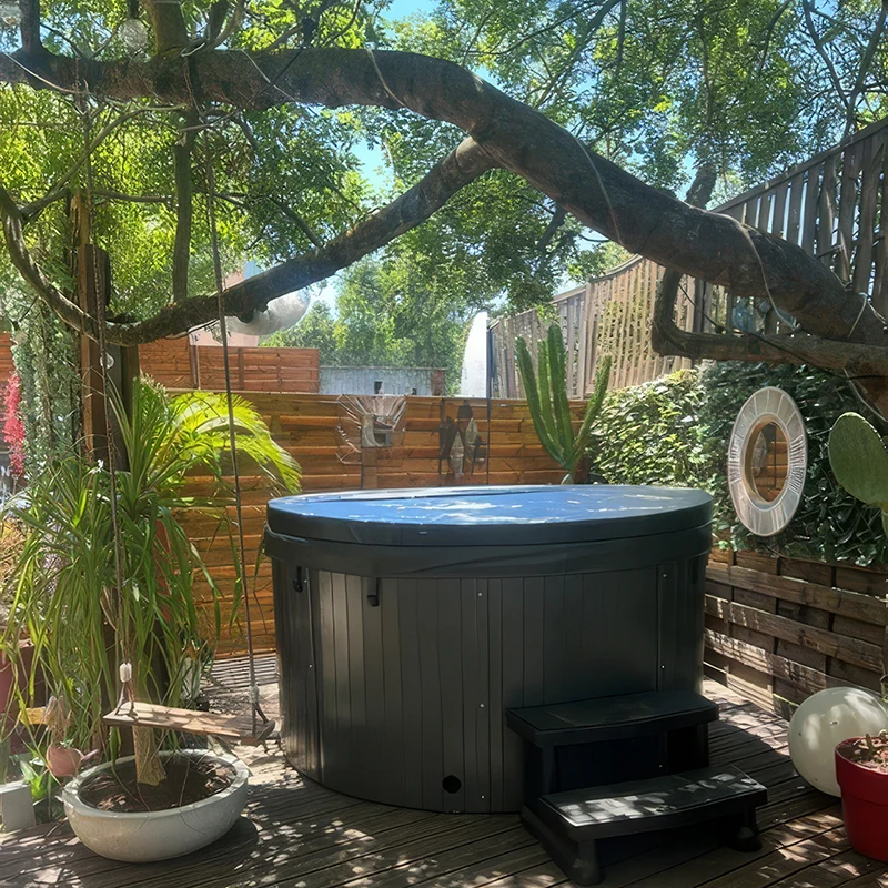 Spa rond 5 places modèle Rimini fermé, installé sur une terrasse en bois entourée de verdure et d'arbres à Grasse
